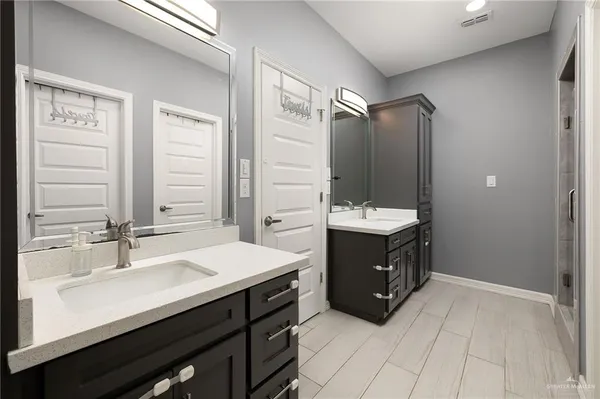 a bathroom with a double vanity sink a mirror and a bathtub
