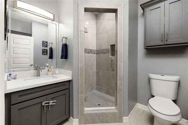 a bathroom with a sink a toilet and shower