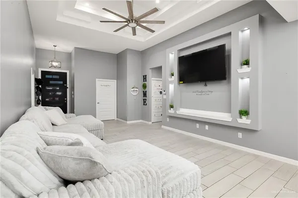 a bedroom with a bed a flat screen tv and a chandelier