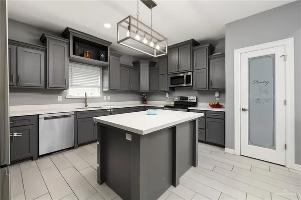 a kitchen with kitchen island granite countertop a sink stove and refrigerator