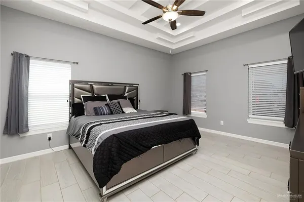 a bedroom with a large bed and a chandelier