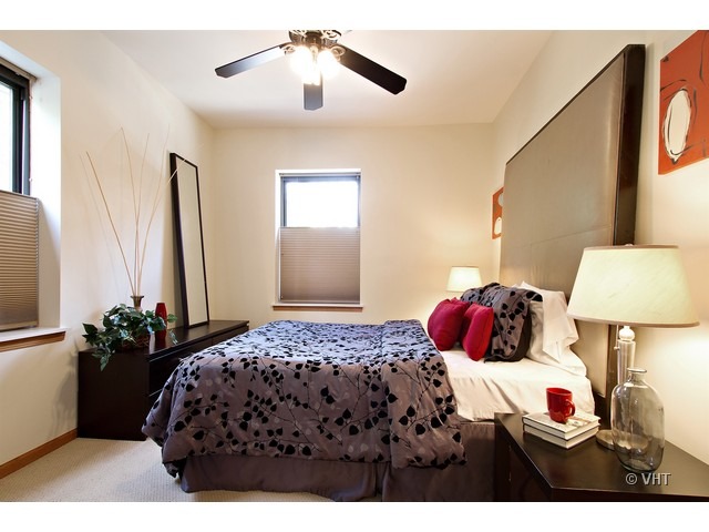 45 North Paulina Street, Unit 1 Chicago, IL 60612 - Photo 8 of 11 a bedroom with a bed and a lamp