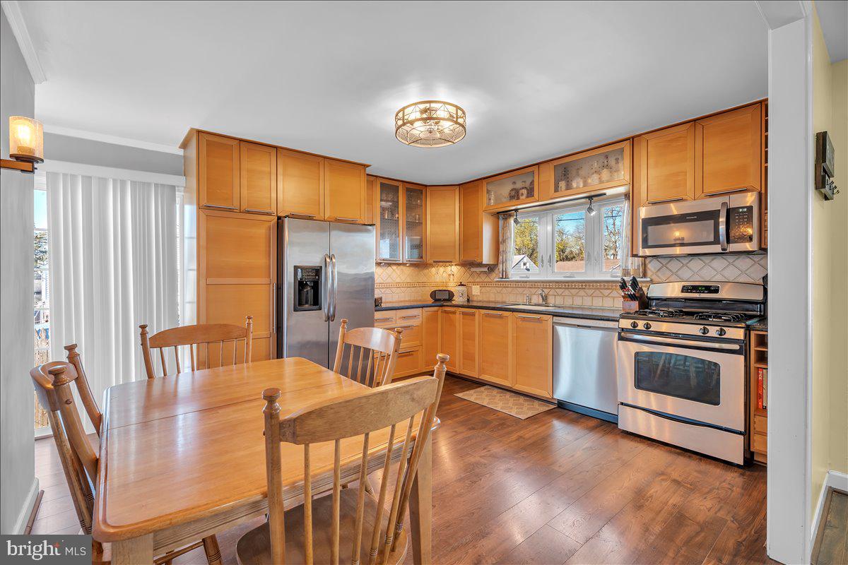 528 Rowand Avenue Glendora, NJ 08029 - Photo 10 of 24 a kitchen with stainless steel appliances granite countertop a sink a stove a refrigerator with a dining table and chairs