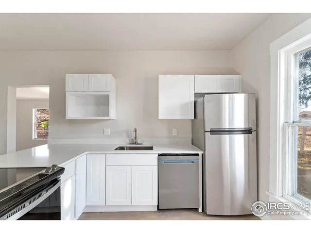 a kitchen with a sink a refrigerator and cabinets