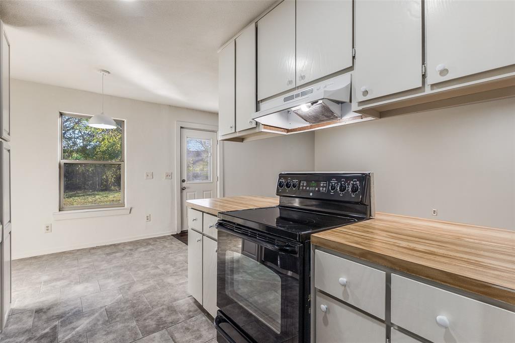 4728 Meadow Ridge Drive Dallas, TX 75236 - Photo 10 of 25 a kitchen with stainless steel appliances granite countertop a sink a stove and a microwave