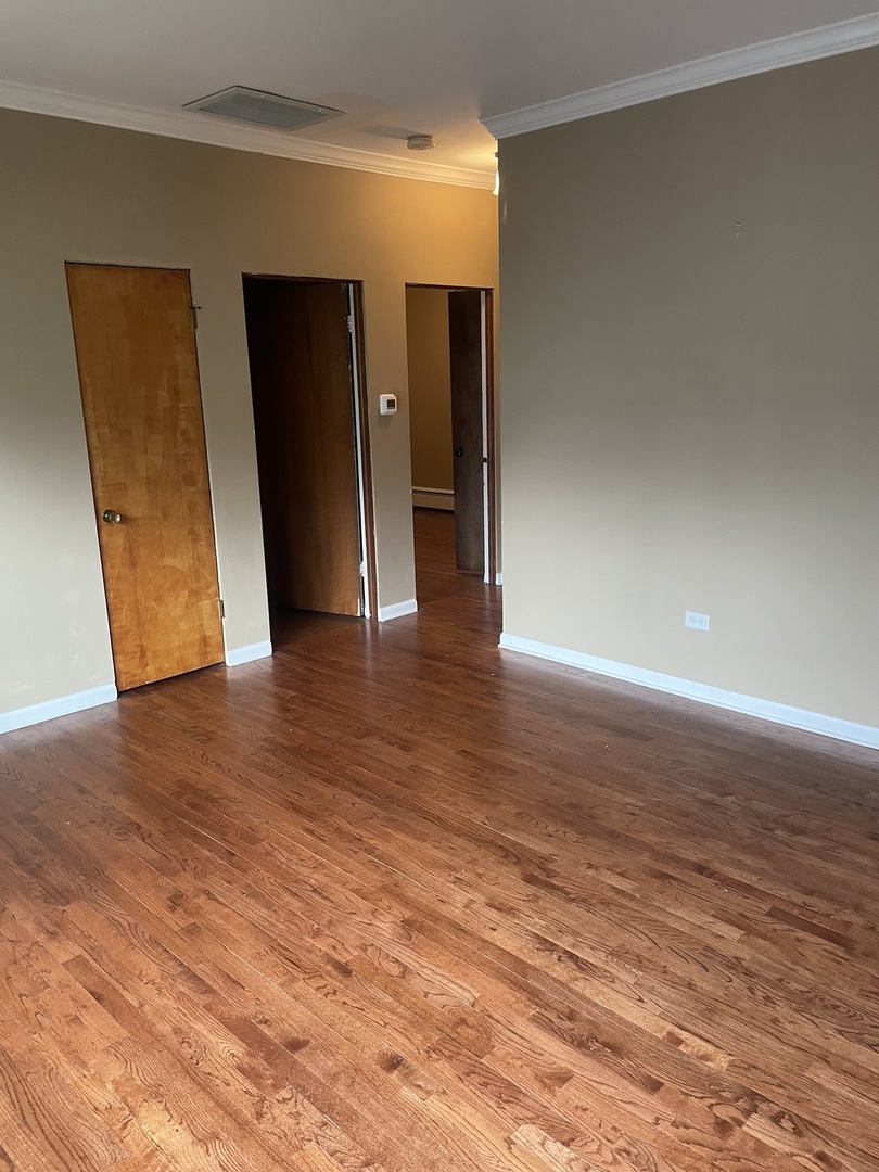 632 North Center Street, Unit 2W Naperville, IL 60563 - Photo 4 of 14 a view of an empty room with wooden floor and closet