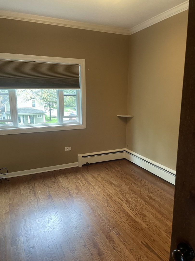 632 North Center Street, Unit 2W Naperville, IL 60563 - Photo 9 of 14 a view of an empty room with wooden floor and a window