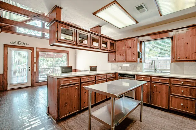 a kitchen with stainless steel appliances granite countertop a stove a sink dishwasher and cabinets with wooden floor
