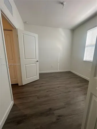 an empty room with wooden floor and white walls