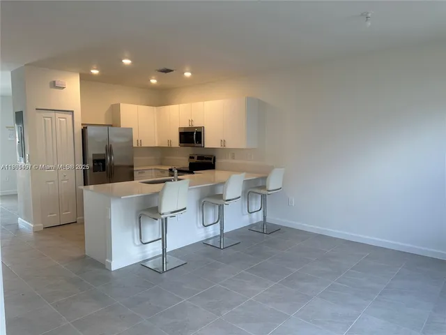 a kitchen with stainless steel appliances a refrigerator and a stove top oven