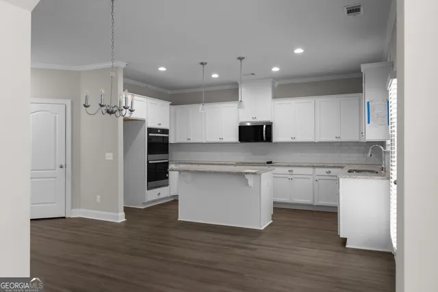 a kitchen with kitchen island a sink stainless steel appliances and cabinets