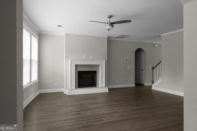 a view of an empty room with a fireplace and a window