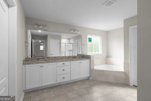 a bathroom with a granite countertop bathtub sink and mirror