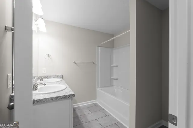a bathroom with a granite countertop sink a toilet and shower