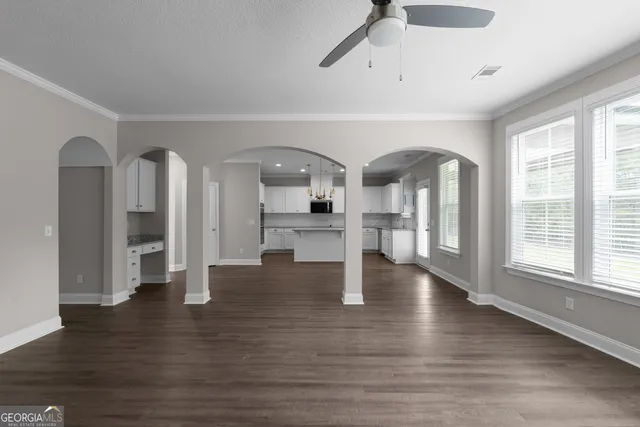 a view of empty room with wooden floor and window