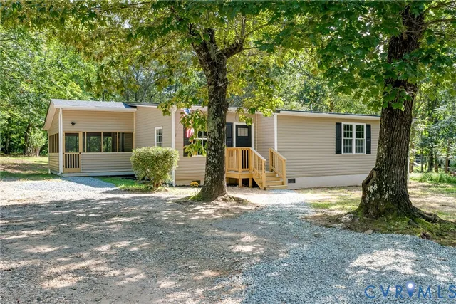 a view of a house with a yard and large tree