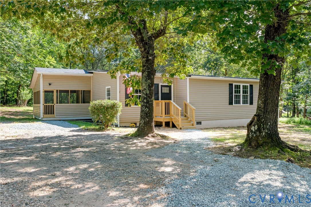 a view of a house with a yard and large tree