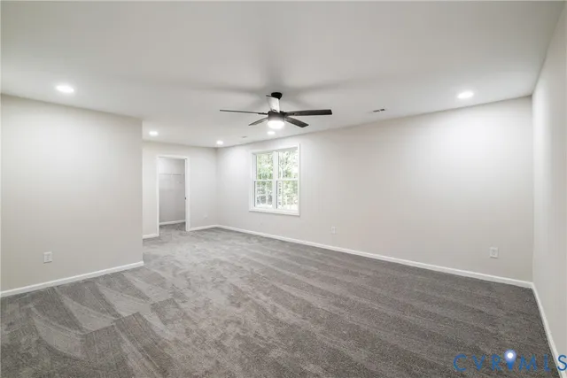 an empty room with a ceiling fan and window