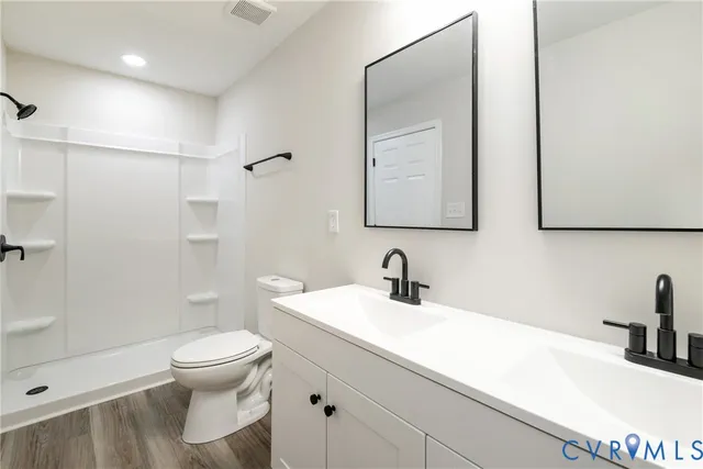 a bathroom with a sink a toilet and shower