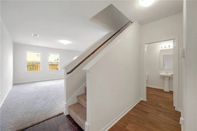 a view of a hallway with wooden floor and staircase