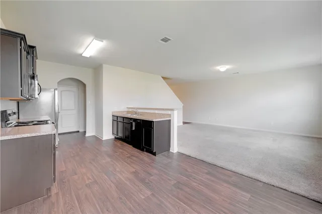 an empty room with wooden floor and a fireplace
