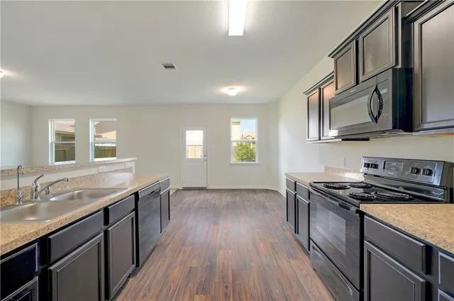 a kitchen with stainless steel appliances granite countertop a sink stove and cabinets