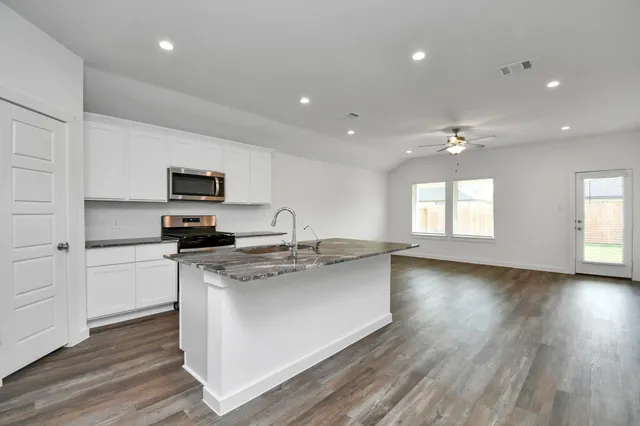 a kitchen with refrigerator and cabinets