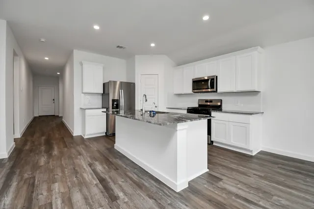 a kitchen with stainless steel appliances granite countertop a sink stove and refrigerator
