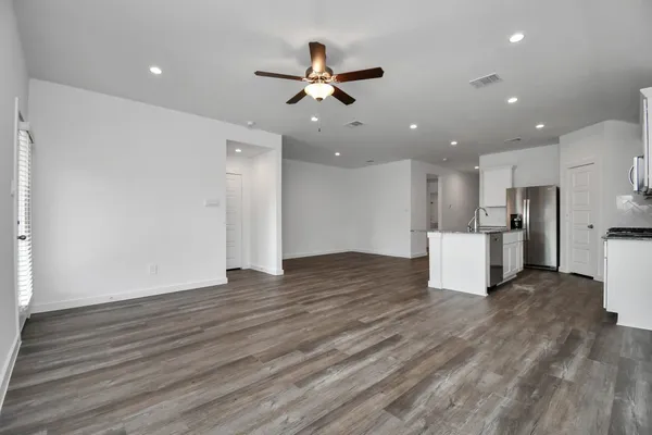 a view of an empty room with a window and wooden floor