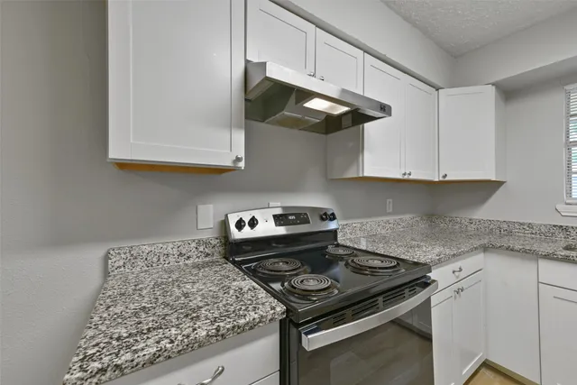 a kitchen with stainless steel appliances granite countertop a stove a sink and a microwave