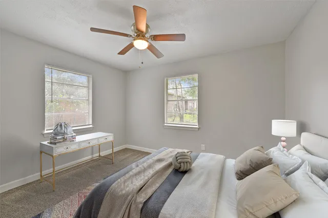 a bedroom with a white bed white couches and a window
