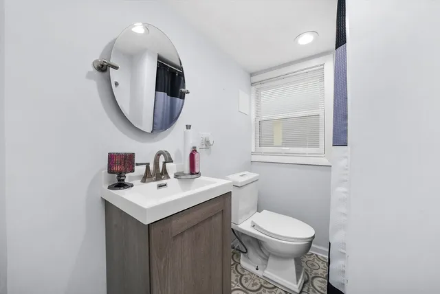 a bathroom with a toilet a sink and mirror