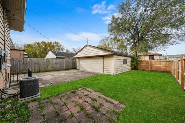 a view of a backyard with table and chairs and wooden fence