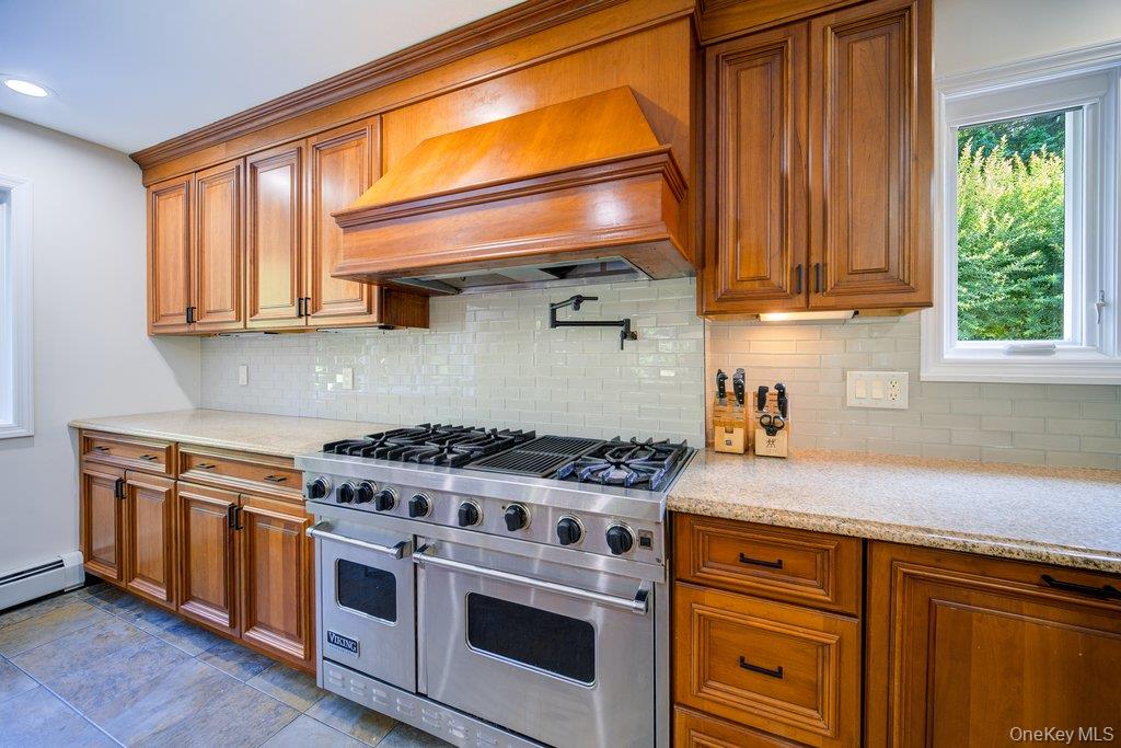237 Mineral Springs Road Highland Mills, NY 10930 - Photo 14 of 32 Kitchen with range with two ovens, brown cabinetry, light stone countertops, tasteful backsplash, and premium range hood
