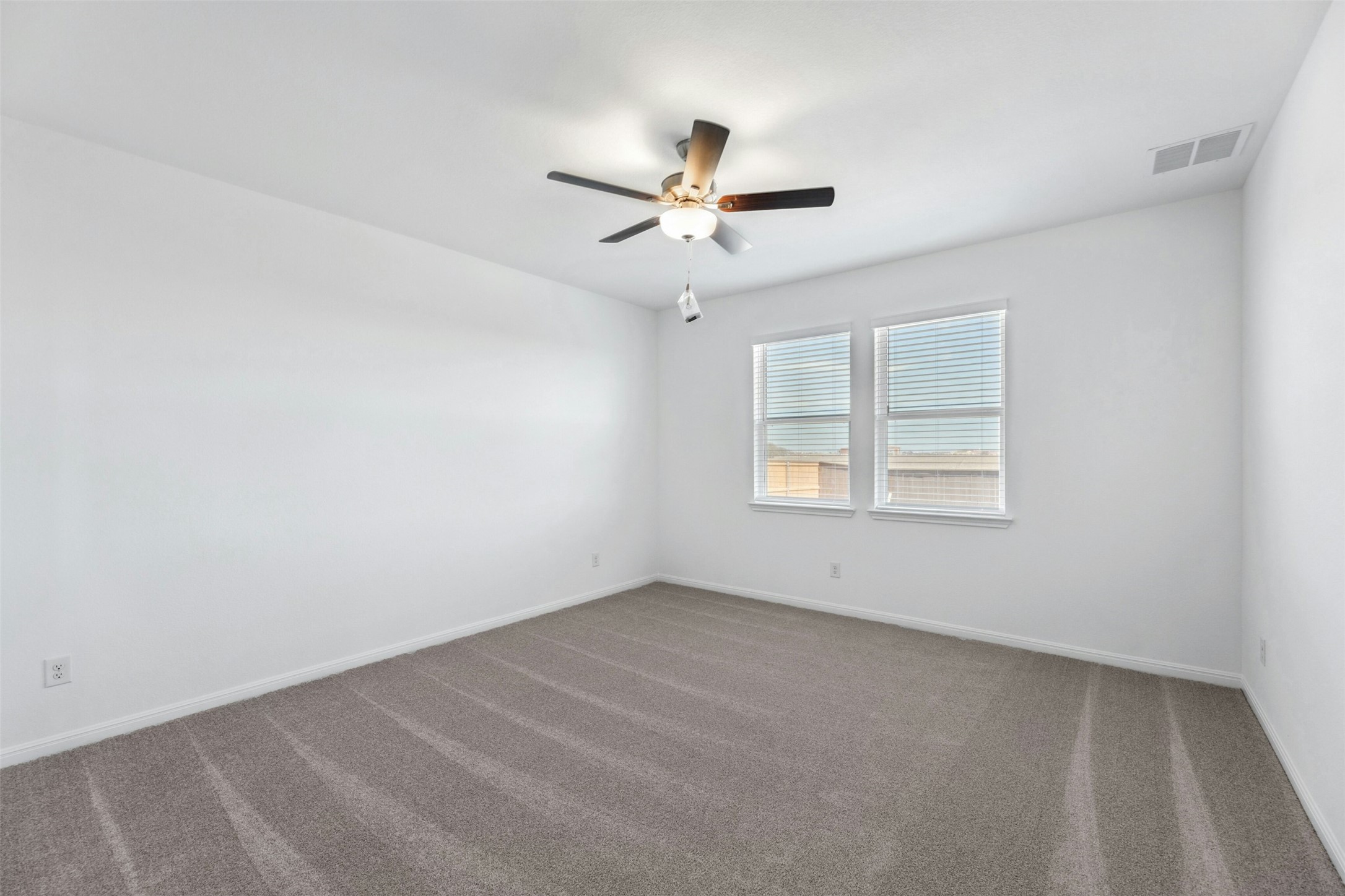2001 Wynn Road Hutto, TX 78634 - Photo 12 of 39 An airy bedroom with dual windows and plush carpet for serene living.