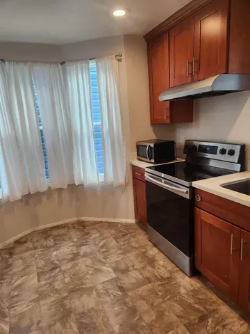 a kitchen with granite countertop a stove a sink and dishwasher
