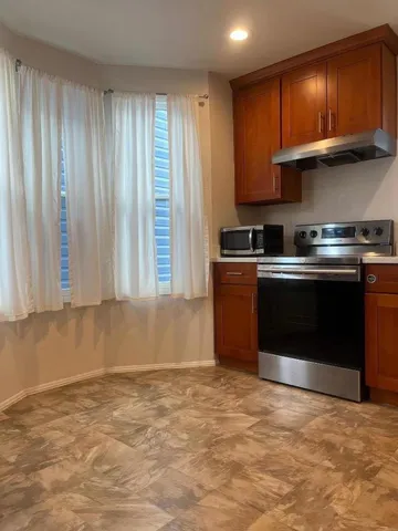 a kitchen with stainless steel appliances granite countertop a stove a sink and a microwave