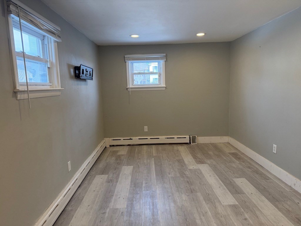 493 Rivet Street New Bedford, MA 02740 - Photo 11 of 20 an empty room with wooden floor and windows