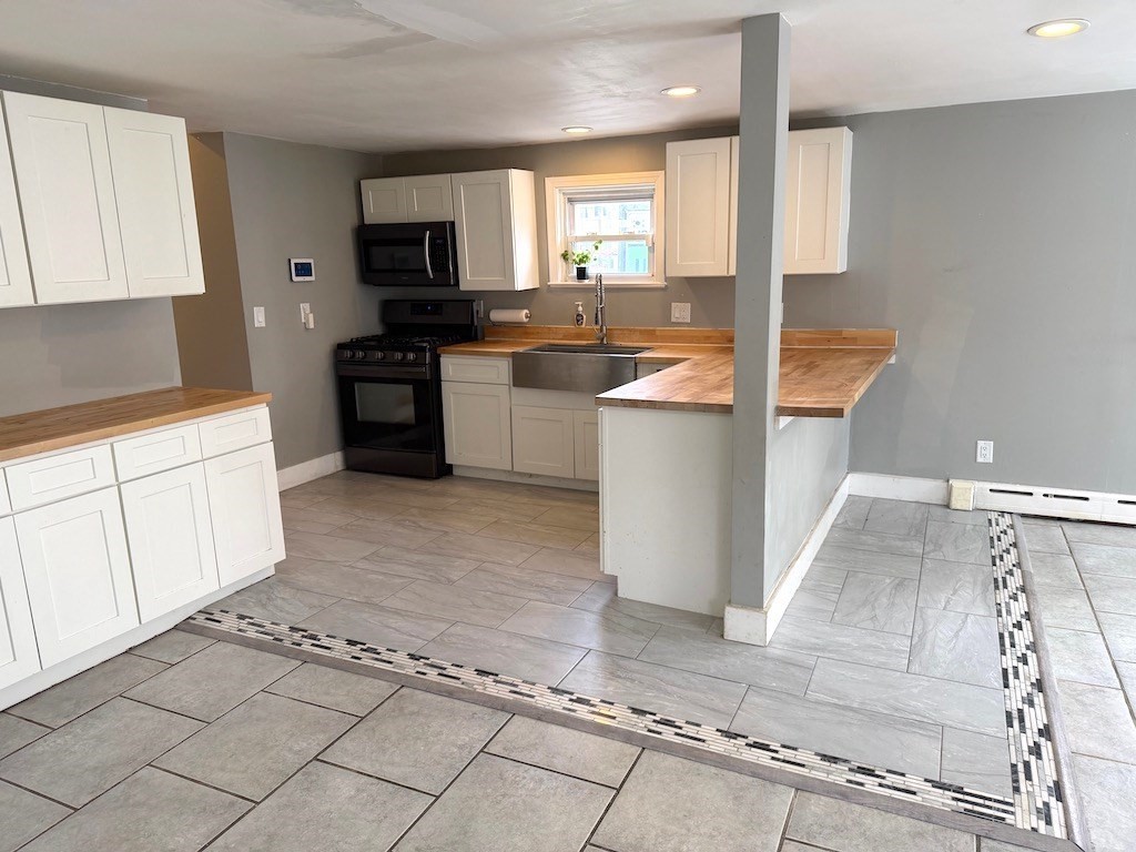 493 Rivet Street New Bedford, MA 02740 - Photo 3 of 20 a kitchen with a sink a counter top space cabinets and stainless steel appliances