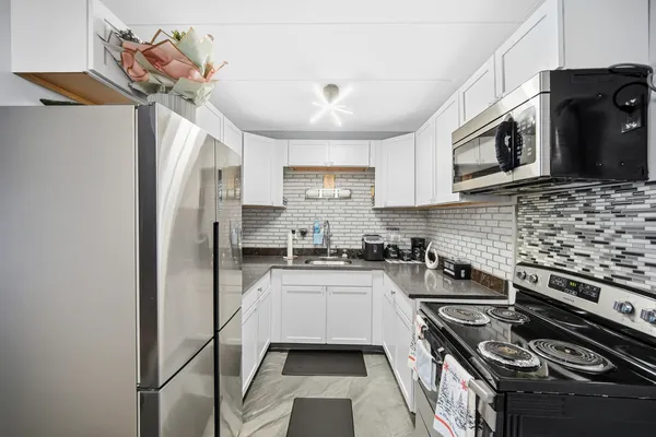 a kitchen with stainless steel appliances a stove a sink and a refrigerator