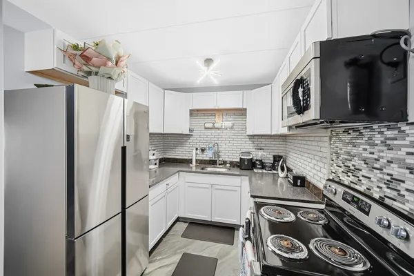 a kitchen with stainless steel appliances a refrigerator a stove a sink dishwasher and a stove with wooden floor