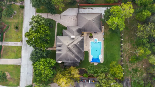 an aerial view of residential houses with outdoor space and trees