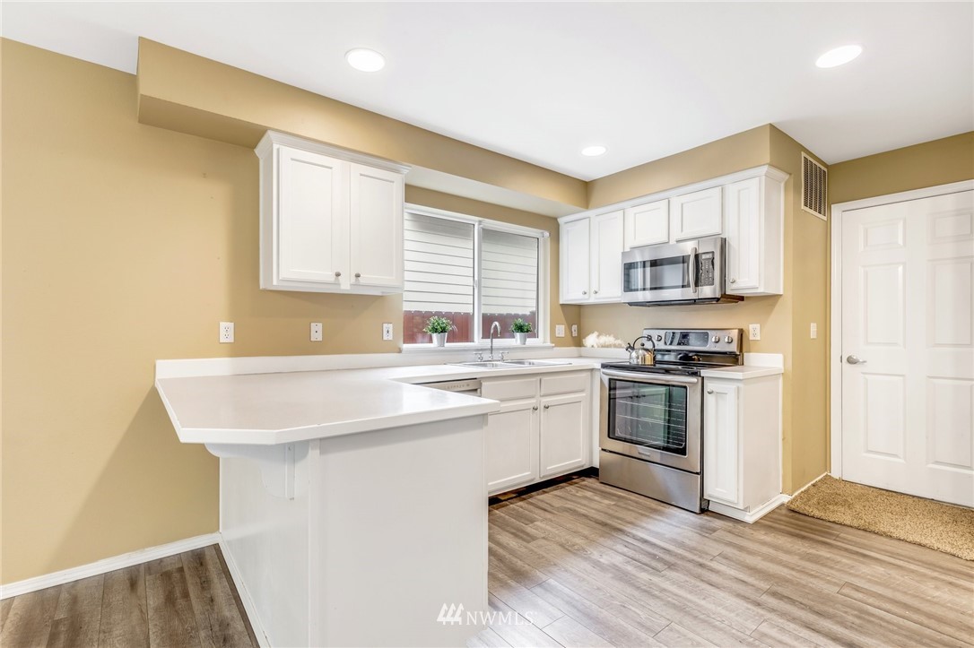 13402 Prospector Ridge Road Southeast Monroe, WA 98272 - Photo 11 of 30 a kitchen with kitchen island granite countertop a sink cabinets and stainless steel appliances