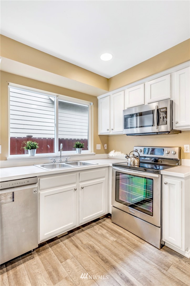 13402 Prospector Ridge Road Southeast Monroe, WA 98272 - Photo 13 of 30 a kitchen with stainless steel appliances granite countertop a stove a sink and a microwave
