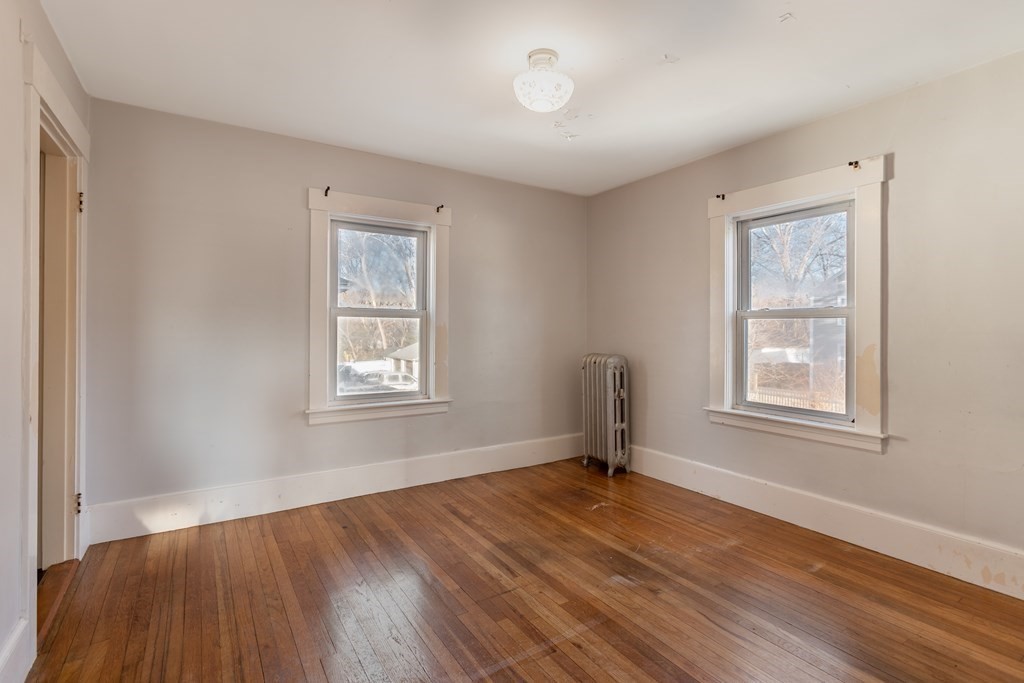 102 Great Road Maynard, MA 01754 - Photo 17 of 32 a view of an empty room with wooden floor and a window