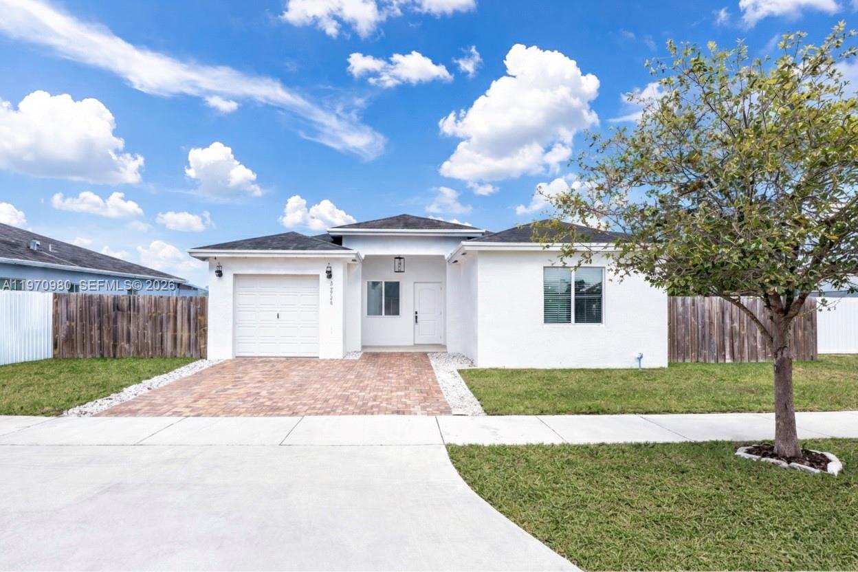 30725 Southwest 158 Path Homestead, FL 33033 - Photo 1 of 29 a front view of a house with a yard and garage
