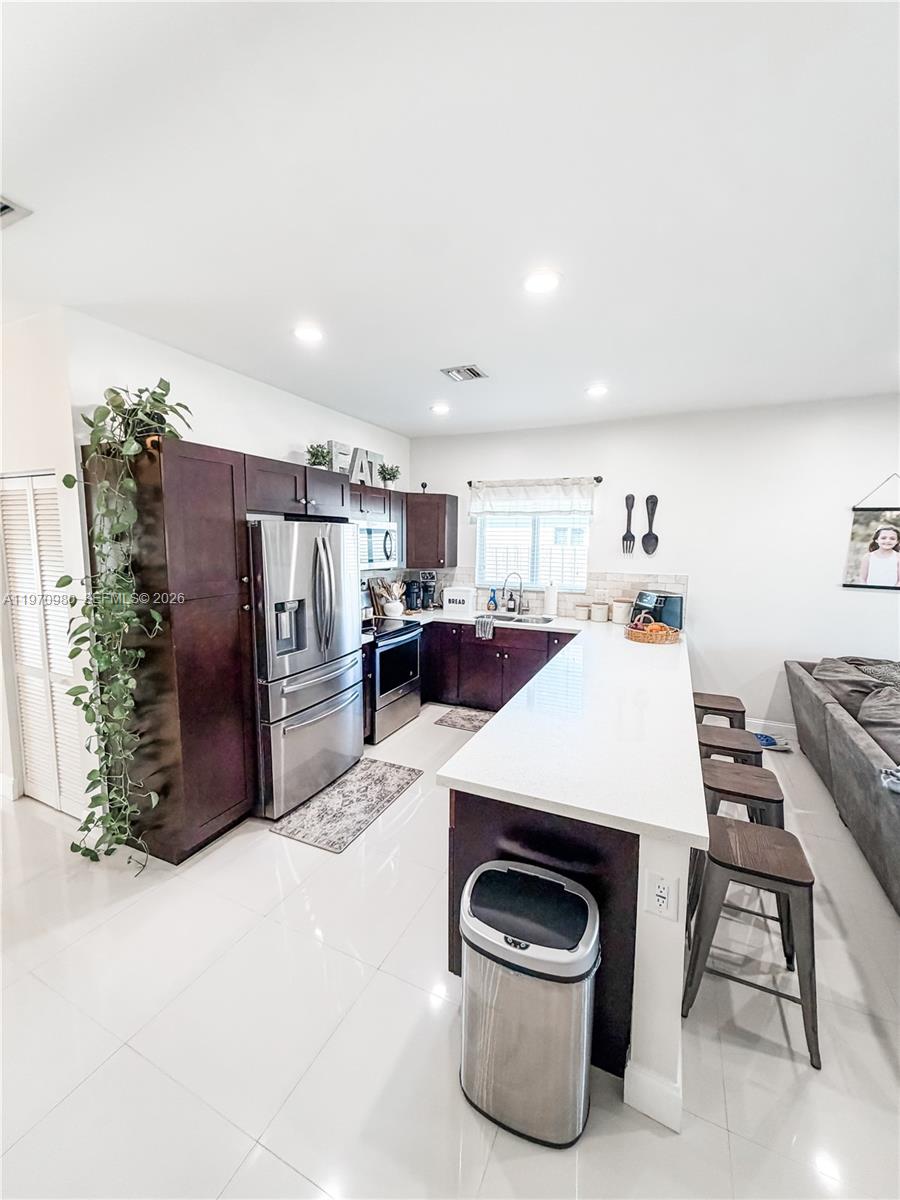 30725 Southwest 158 Path Homestead, FL 33033 - Photo 4 of 29 a kitchen with stainless steel appliances a refrigerator and a stove top oven