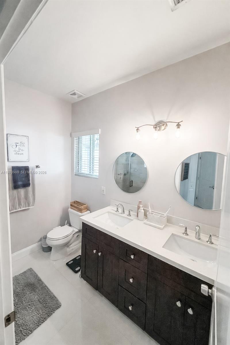 30725 Southwest 158 Path Homestead, FL 33033 - Photo 9 of 29 a bathroom with a double vanity sink double mirror and toilet