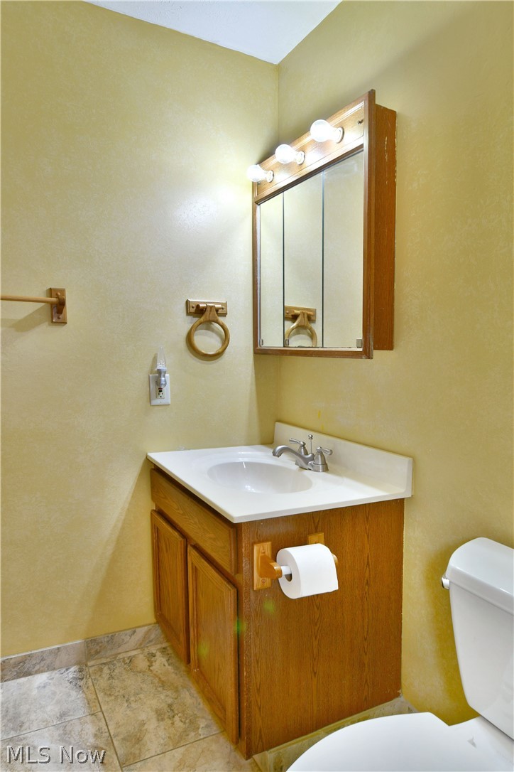 3287 Pheasant Run Road, Unit B Cortland, OH 44410 - Photo 42 of 45 Vanity with integrated sink, wood-finish cabinetry, and a mirrored medicine cabinet