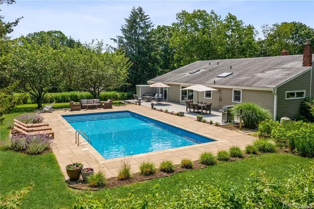 a swimming pool with outdoor seating and yard